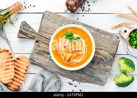 Kürbis-Creme-Suppe in einer Schüssel mit Toastbrot. Diätetische Speisen. Draufsicht. Freier Speicherplatz. Stockfoto