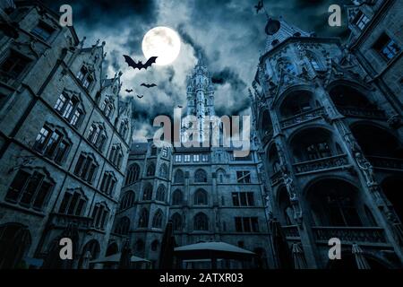 Marienplatz in der Nacht, München, Deutschland. Gruseliger geheimnisvoller Blick auf das dunkle, Gotische Rathaus mit Fledermäusen. Alte, spoky Burg oder Palast in Vollmond. Furchtsam düster Stockfoto