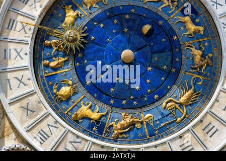 Alte Uhr (Torre dell'Orologio) auf dem Markusplatz in Venedig, Italien. Detail mit gestecktem Gesicht und Tierkreiszeichen. Stockfoto