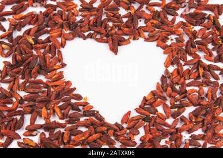 Jede Menge Goji-Beeren auf weißem Hintergrund in Form eines Herzens Stockfoto