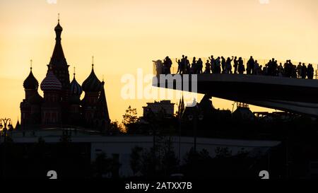 Moskau bei Sonnenuntergang, Russland. Schwebende Brücke mit Blick auf die St Basil's Cathedral. Der Zaryadye Park ist eine Touristenattraktion Moskaus. Die Menschen besuchen Moskau l Stockfoto