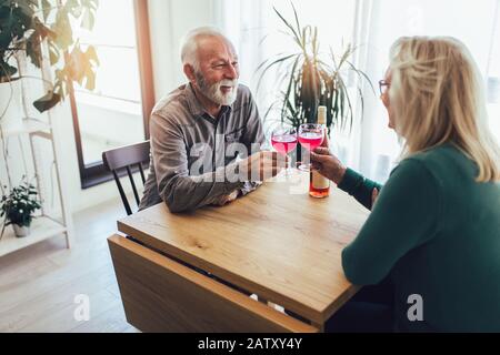 Senior Paar zu Hause trinken Rotwein Stockfoto