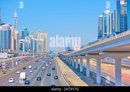 Dubai, OAE - 30. Januar 2020: Perspektive der Scheich Zayed Road mit modernen Wolkenkratzern und U-Bahn-Linie in Dubai Stockfoto