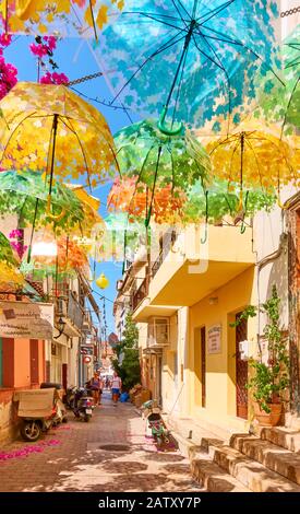 Ägina, Griechenland - 12. September 2019: Straße mit Sonnenschirmen in verschiedenen Farben in der Stadt Ägina Stockfoto