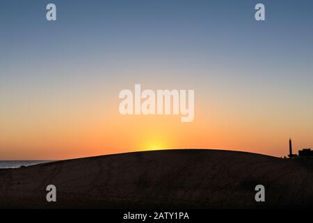 Maspalomas Dünen und Leuchtturm in Silhouette bei Sonnenuntergang, Gran Canaria, Kanarische Inseln Stockfoto