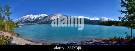 Schöner blauer Abraham-See mit hohen Bergen, die im Hintergrund schneebedeckt sind. Sonniger Tag, blauer Himmel, Kootenay Ebenen Ökologisches Reservat. Kanada. Stockfoto