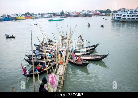 Menschen, die vom Holzboot am Bootsterminal im Burigonga-Fluss abfahren, um den Fluss in Sadarghat dhaka bangladesh zu überqueren Stockfoto