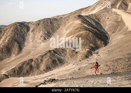 Mann, der auf der Wüste in der Nähe des Besique Beach (Balneario de Besique) spazieren geht. Chimbote, Department of Ancash, Peru. Stockfoto