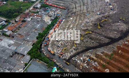 Luftansicht. Große Mülldeponien wie Berge: Der Traktor nimmt Müll auf Mülldeponien in Bekasi - Indonesien Stockfoto