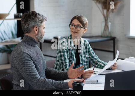 Innenarchitekten arbeiten im Büro mit Blaupausen und Architektenausstattung, skizzieren, verhandeln und planen Bauvorhaben. Partner Stockfoto