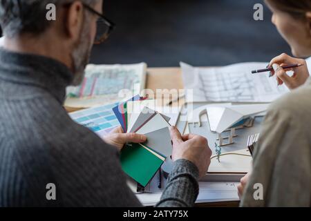 Innenarchitekten arbeiten im Büro mit Farbpalette. Architekten wählen Farben für das Gebäude mit Farbfeldern, Skizzen und Planungskonst aus Stockfoto