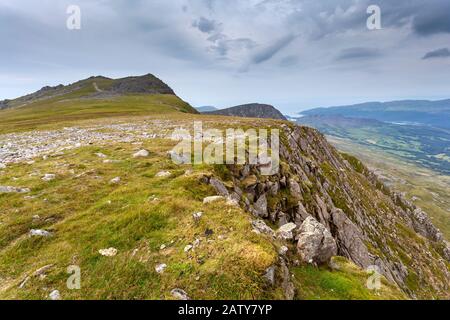 Blick zurück auf den Grat zum Gipfel von Cadair Idris, mit grauem bewölktem Himmel, Snowdonia National Park, Nordwales Stockfoto