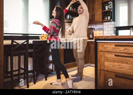 Glückliches Paar tanzen in der Küche zu Hause. Stockfoto