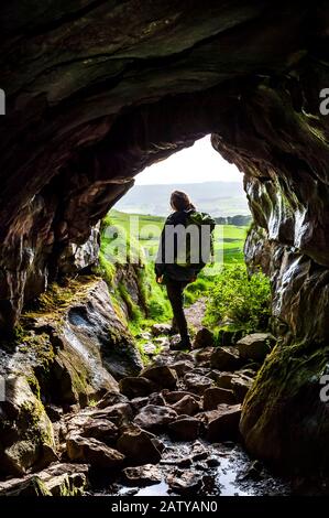 Dominika Wroblewska in einer Innenansicht des phreatisch entwickelten Eingangs zur Jubilee Cave in Langcliffe Scar, Yorkshire Dales National Park Stockfoto