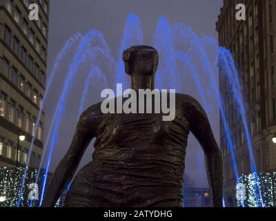 Henry Moors Drapierte Sitzende Frau Kopf und Schultern mit blauem Findtain Light in Canary Wharf während der Winter Lights 2020 im Dunkeln nachts Stockfoto