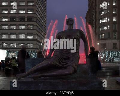 Henry Moors Drapierte Sitzende Frau voller Körper mit rotem Findtain Light in Canary Wharf während der Winter Lights 2020 im Dunkeln nachts Stockfoto