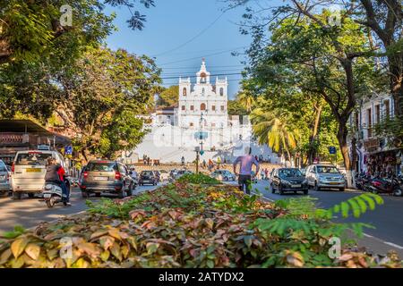 Panaji, Goa, Indien - 27. Februar 2018: Makellose Empfängniskirche von der Straße mit Bäumen und einigen Menschen aus gesehen Stockfoto