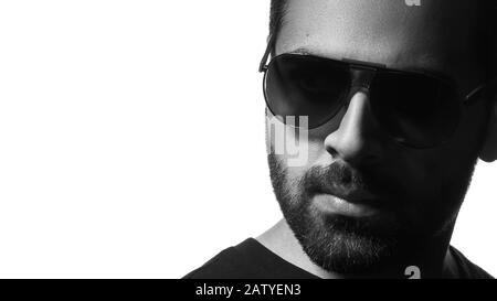 Schwarz-weißer Kopfschuss von arabischem Mann mit Sonnenbrille auf weißem Hintergrund und Kopierraum Stockfoto