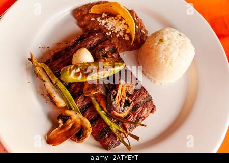 Carne Asada ist ein lokaler Favorit in Puerto Vallarta, Jalisco, Mexiko. Hier wird es mit gegrillten Paprika beschichtet und mit einer Seite Reis serviert. Stockfoto