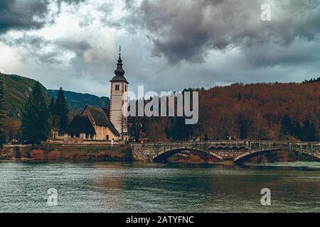 Schöner Blick auf die alte Kirche, die dem heiligen Johannes dem Täufer am Bohinjer See in Slowenien gewidmet ist Stockfoto