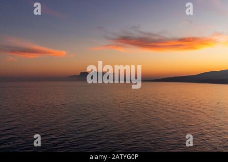 Atemberaubender Sonnenuntergang auf dem von Nebel umgebenen Felsen von Gibraltar, der von Spanien aus gesehen wird Stockfoto