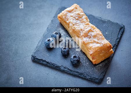 Gebäckdessert mit Puderzucker und Blaubeeren Stockfoto