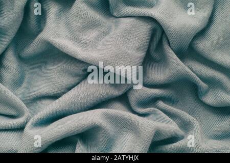 Hellgrauer, zerknitterter Wolltexturhintergrund. Nahaufnahme. Stockfoto