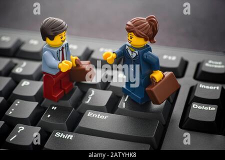 Tambov, Russische Föderation - 24. Januar 2020 Lego Geschäftsmann und Geschäftsfrau Minifiguren stehen auf einer schwarzen Computertastatur. Stockfoto