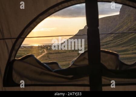 Blick von einem Zelt auf dem Dach auf dem Surferparadies Unstad auf den Lofoten Inseln, Norwegen. Vanlife bei Sonnenuntergang. Stockfoto