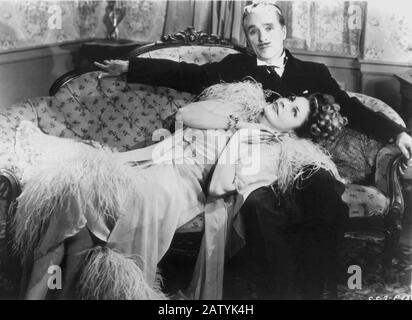 CHARLES CHAPLIN ( 1889 - 1977 ) IN MONSIEUR VERDOUX ( 1947 ) - Landrou - omicida - Serienmörder - divano - Couch - piume di struzzo - plume ostric Stockfoto