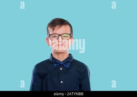 Stilvoller Junge in Hemd und Brille mit großem Lächeln. Ok. Schule. Vorschule. Mode. Studio-Porträt über blauem Hintergrund Stockfoto