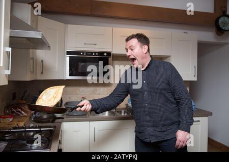 Ein Mann wirft einen Pfannkuchen, Großbritannien Stockfoto