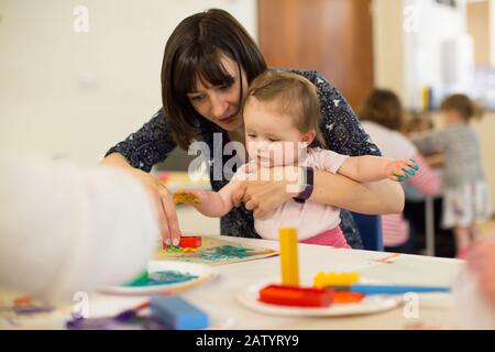 Baby-Gruppe spielt mit Farben, Großbritannien Stockfoto