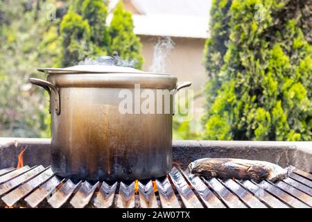 Zubereitung von Suppe in einem Topf, in der Natur. Suppe durch das Holzfeuer kochen Stockfoto