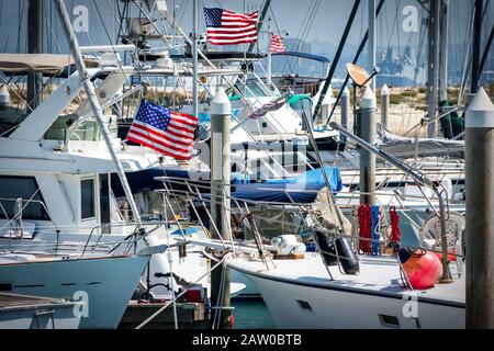 Amerikanische Flaggen fliegen auf Booten in einem südkalifornischen Yachthafen. Stockfoto