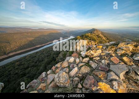 Atemberaubende Aussicht während des Sonnenuntergangs auf die Extremadura-Felder, ihre Wälder und den Tajo-Fluss vom atemberaubenden Monfrague Castle im Monfrague National Park Stockfoto