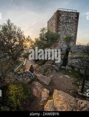 Eine Outdoor-Frau Touristen genießen die erstaunliche Aussicht während des Sonnenuntergangs von Extremadura Landfelder, es Wälder und Tajo Fluss von der atemberaubenden Burg Monfragûe Stockfoto