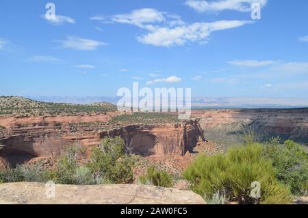 Sommer im Colorado National Monument: Monument Canyon Von Coke Ovens Aus Gesehen, Blick Auf Rim Rock Drive mit Grand Valley und den Book Cliffs Beyond Stockfoto