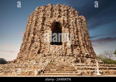 Großer ruinierter Turm im Qutub Minar Komplex in Neu-Delhi, Indien bei lila Sonnenuntergang Stockfoto