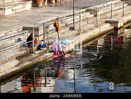 Udaipur, RAJASTHAN, INDIEN - 03. MÄRZ 2015: Frau wäscht ihre Kleidung mit traditioneller Methode im Fluss in der Stadt Udaipur. Stockfoto