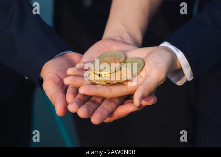 Junge asiatische Geschäftsmann und Goldene bitcoin vor seinem Internationalen multi-ethnische Teams in der modernen Stadt. Stockfoto