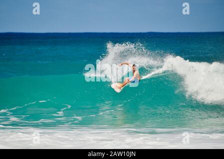 Surfer, die in Der Banzai-Pipeline an North Shore, Oahu Island, Haleiwa, Hawaii, USA, mit weltweit bekannten, krachenden, geschwungenen türkisfarbenen Wellen reiten Stockfoto