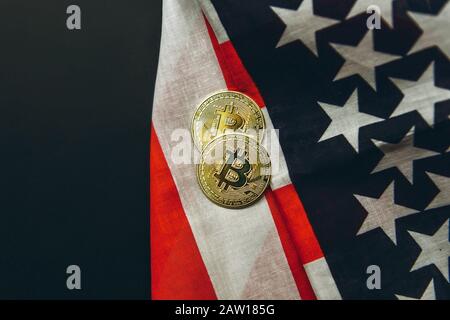 Bitcoin Cryptocurrency Münzen neben amerikanischem Flaggenhintergrund. Stockfoto