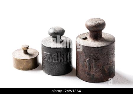 Alte rustikale Metallgewichte auf weißem Hintergrund. Stockfoto