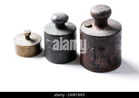 Alte rustikale Metallgewichte auf weißem Hintergrund. Stockfoto