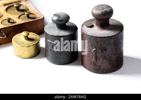 Alte rustikale Metallgewichte auf weißem Hintergrund. Stockfoto