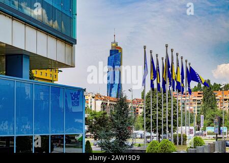 Blick auf die Stadtviertel von Sarajevo, vom Parlamentsgebäude mit Flaggen und dem berühmten Avaz Twist Tower. Stockfoto