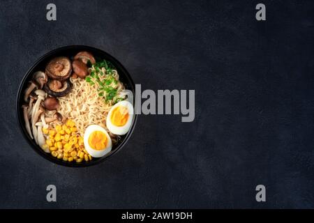 Ramen. Soba-Nudeln mit Eiern, Shiitake und Enoki-Pilzen, Mais und Hengst, oben auf schwarzem Hintergrund mit Platz für Text geschossen Stockfoto