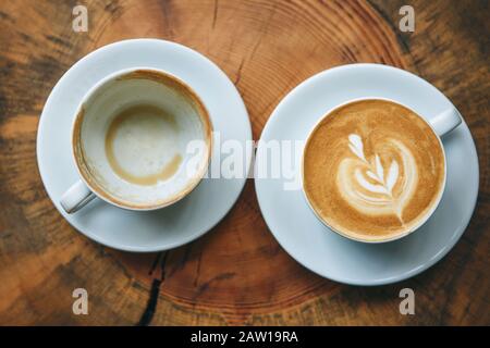 Volle und leere Tasse Kaffee. Das Konzept von Anfang und Ende, Anfang und Ende. Stockfoto