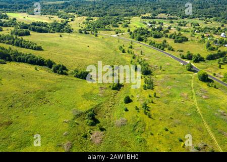 Luftbild von oben auf einem Feld und einem Wald auf einem Hügel Stockfoto